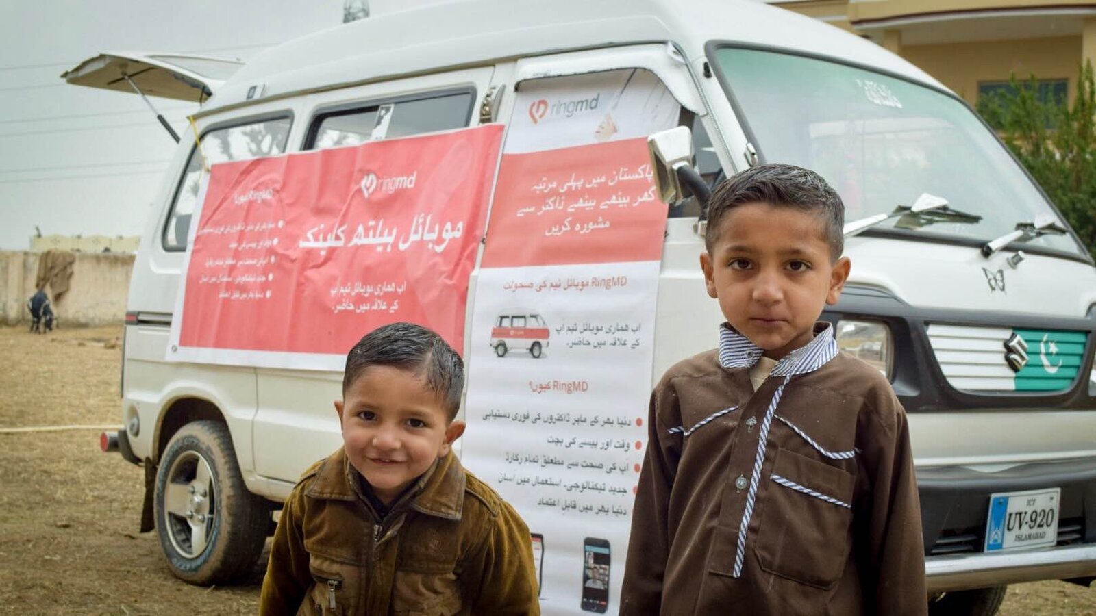 Children beside a RingMD mobile health clinic van in Pakistan